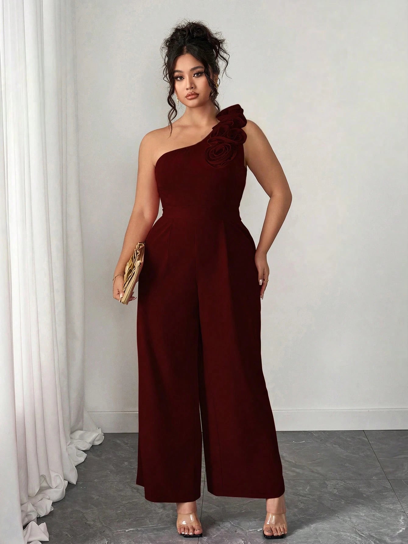 Macacão Plus Size Pantalona Assimétrico com Flor no Ombro